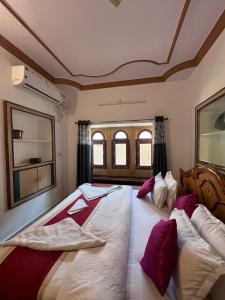 ein Schlafzimmer mit einem großen Bett mit lila Kissen in der Unterkunft Golden villa in Jaisalmer
