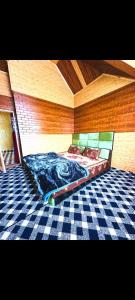 a bed in a room with a checkered floor at Gulmarg View Guest House in Khor