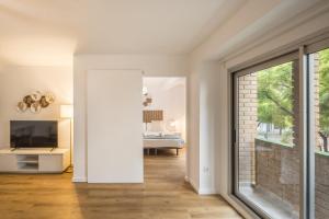 een woonkamer met een glazen schuifdeur en een slaapkamer bij Macflats Ciudad de las Ciencias in Valencia