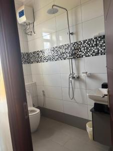 a bathroom with a shower and a toilet and a sink at Garden house in Kajansi