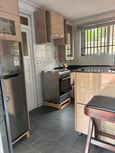 a kitchen with a stove and a refrigerator at Garden house in Kajansi