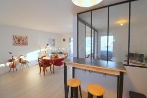 eine Küche und ein Esszimmer mit Tisch und Stühlen in der Unterkunft L'Aigue Marine by TAH - Top emplacement & Parking in Pornichet