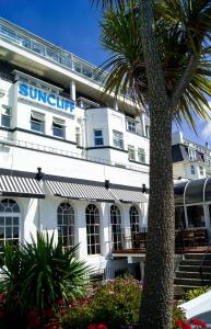 ボーンマスにあるSuncliff Hotel - OCEANA COLLECTIONのヤシの木が目の前にある建物