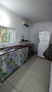 a kitchen with a sink and a refrigerator at Coração do Mar in Cayru