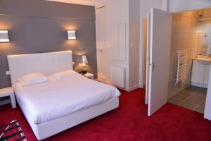 - une chambre avec un lit blanc et un tapis rouge dans l'établissement Hôtel Le Square, à Aurillac