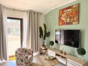 a living room with a tv and a chair at Stay at Searle in Kirkwood
