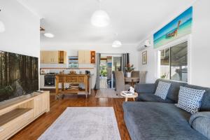 een woonkamer met een bank en een tafel bij Ma Te Kokorou - pet-friendly Huskisson pool escape in Huskisson