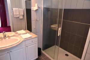 een badkamer met een douche en een wastafel bij Hôtel Le Square in Aurillac