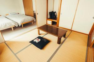 une petite chambre avec un lit et un miroir dans l'établissement 南町ハウス, à Biei