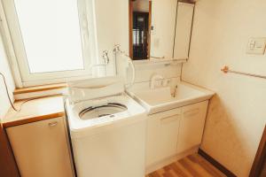 une salle de bains avec lave-linge et lavabo dans l'établissement 南町ハウス, à Biei 28 autres photos