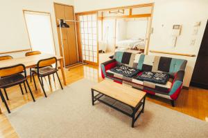un salon avec un canapé et une table dans l'établissement 南町ハウス, à Biei