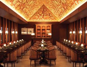 a dining room with tables and chairs and a gold ceiling at Hotel Kiridara Luang Prabang in Luang Prabang