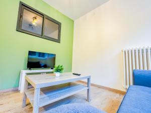 a living room with a table and a tv at Appartement lumineux à Royat in Royat