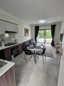 a kitchen and living room with a table and chairs at 77 on Par in Boksburg