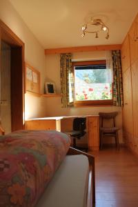 a bedroom with a bed and a desk and a window at Haus Kofler in Casateia