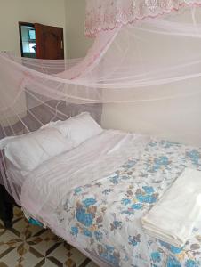 a bedroom with a bed with a canopy at Lakeside Beach Hotel in Madwa +7 photos