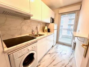 a kitchen with a sink and a washing machine at Palais des Domes Gloria in Nice