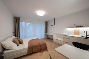 a white bedroom with a bed and a kitchen at Studio 4 in Bad Schallerbach