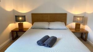 een slaapkamer met 2 handdoeken op een bed met 2 lampen bij Maisonnette duplex in Bouguenais