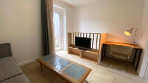 een woonkamer met een salontafel en een flatscreen-tv bij Maisonnette duplex in Bouguenais