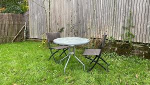 een tafel en twee stoelen in een tuin bij Maisonnette duplex in Bouguenais