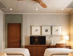 a room with two beds and a television at Hotel Kiridara Luang Prabang in Luang Prabang