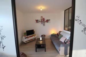 ein Wohnzimmer mit Sofa und Fernseher in der Unterkunft L'Aigue Marine by TAH - Top emplacement & Parking in Pornichet