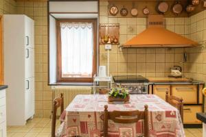 una cucina con tavolo e tovaglia; di Casa tipica nelle Dolomiti Trentine a Mezzano