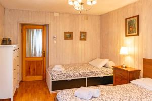 una camera da letto con due letti, una lampada e una finestra di Casa tipica nelle Dolomiti Trentine a Mezzano