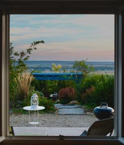 Aussicht aus einem Fenster mit einem Tisch und Stühlen in der Unterkunft La Villa Mellifera in Cernay-lès-Reims