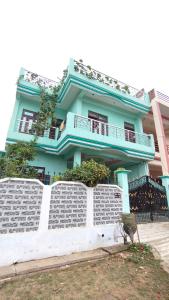 a blue building with a fence in front of it at Ajay homestay &PG in Jhūsi