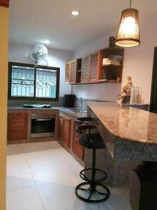 a kitchen with a counter and a island in it at phu petra villa in Ao Nang 
