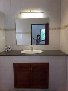 a woman taking a picture of a bathroom sink at phu petra villa in Ao Nang  +13 photos
