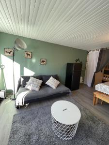 a living room with a couch and a table at Studio Buron des Gardes in Le Lioran