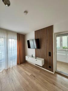 ein Wohnzimmer mit einem Fernseher an der Wand in der Unterkunft Ferienwohnung in Hanau am Main