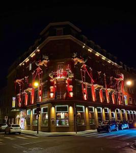 een gebouw met vlaggen aan de zijkant 's nachts bij Best Western Plus Monopole Métropole in Straatsburg