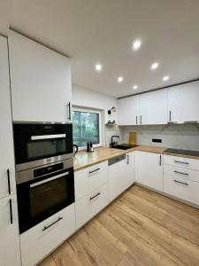 eine Küche mit weißen Schränken und schwarzen Geräten in der Unterkunft Ferienwohnung in Hanau am Main