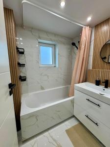 ein Badezimmer mit einer weißen Badewanne und einem Waschbecken in der Unterkunft Ferienwohnung in Hanau am Main + 13 Fotos
