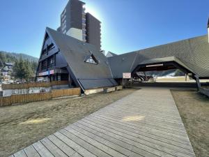 a building with a wooden walkway in front of a building at Studio Buron des Gardes in Le Lioran