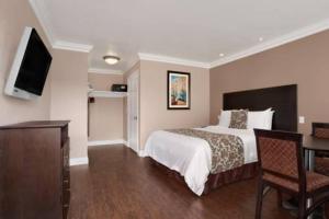 a hotel room with a bed and a desk and a television at Lotus of Lompoc - A Great Hospitality Inn in Lompoc