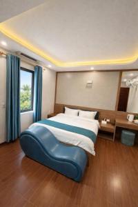 ein Schlafzimmer mit einem großen Bett mit einem blauen Ottomanen in der Unterkunft Phương Anh Villa Pro in Bắc Ninh