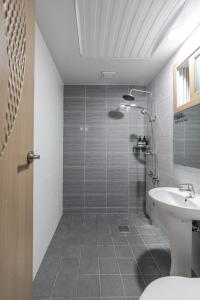 een badkamer met een douche, een toilet en een wastafel bij 감성제주스테이 in Songnang-dong