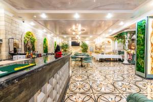 a lobby of a hotel with a bar and tables at РИМ Garden in Almaty