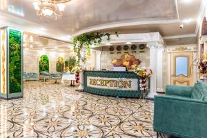 a hotel lobby with a reception desk and chairs at РИМ Garden in Almaty