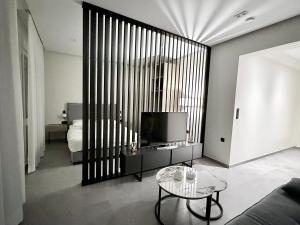 a living room with a tv and a bed and a table at Bright 7th floor Studio-Near Center of Xanthi in Xanthi