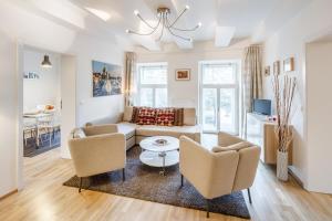 uma sala de estar com um sofá, cadeiras e uma mesa em Residence Vinohrad em Praga