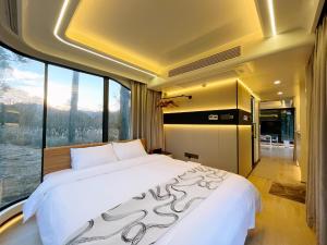 a large bed in a room with a large window at space-vessel基地 in Yufu +29 photos