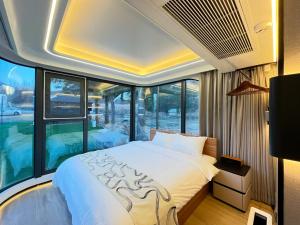 a bedroom with a large bed and a large window at space-vessel基地 in Yufu
