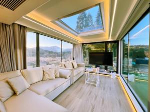 a living room with a white couch and large windows at space-vessel基地 in Yufu
