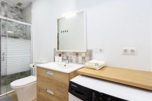 a white bathroom with a sink and a toilet at Apartamento Retama Laguna Centro in Las Lagunas +21 photos